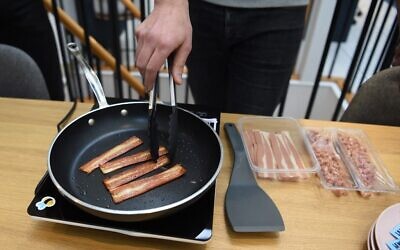 French startup 'La Vie' co-founder and CEO Nicolas Schweitzer cooks their veggie recipe bacon sticks at their headquarters in Paris on January 7, 2022. (Photo by Eric Piermont/AFP)
