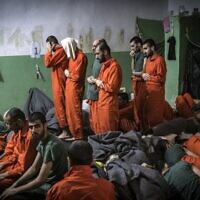 This file photo, taken on October 26, 2019, shows men suspected of being affiliated with the Islamic State (IS) group, praying in a cell of the Sinaa prison in the Ghwayran neighborhood of the northeastern Syrian city of Hasakeh. (Fadel Senna/AFP)