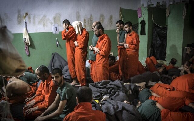 This file photo, taken on October 26, 2019, shows men suspected of being affiliated with the Islamic State (IS) group, praying in a cell of the Sinaa prison in the Ghwayran neighborhood of the northeastern Syrian city of Hasakeh. (Fadel Senna/AFP)