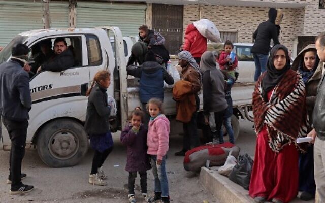Syrians flee their homes in the Ghwayran neighbourhood in the northern city of Hasakeh on January 23, 2022, on the fourth day of fighting between the Kurdish forces and Islamic State (IS) group fighters. (AFP)