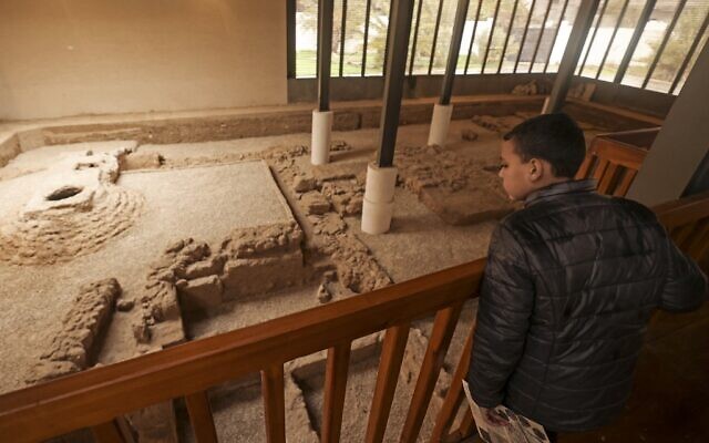 A boy looks at the remnants of a Byzantine church during the inauguration of Mukheitim archaeological site in Jabalia in the northern Gaza Strip on January 24, 2022. (Mahmud HAMS / AFP)