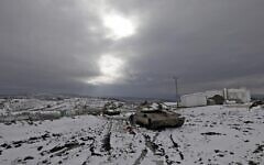 Israel soldiers stand near a Merkava IV battle tank parked in a military post near the Syria border in the Israeli-annexed Golan Heights on January 24, 2022. (JALAA MAREY / AFP)