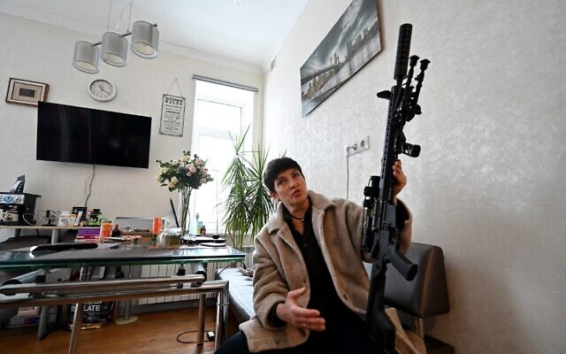 Mariana Zhaglo, mother-of-three, holds her Ukrainian Z-15 - Zbroyar rifle during an interview in the kitchen of her apartment in Kyiv, on January 28, 2022. (Sergei Supinsky/AFP)
