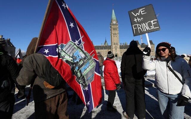 A demonstrator carries a US Confederate flag during the Freedom Convoy protest against COVID-19 vaccine mandates and restrictions, in front of the Canadian Parliament in Ottawa, on January 29, 2022. (Dave Chan/AFP)