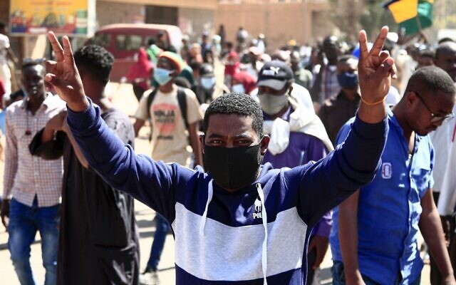 A Sudanese demonstrator flashes the victory sign as he takes part in a rally to protest against last year's military coup, in the capital Khartoum, on January 30, 2022. (AFP)