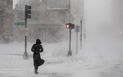 A person crosses the street during white-out conditions as Winter Storm Kenan bears down on January 29, 2022 in Boston, Massachusetts. (Photo by Scott Eisen / GETTY IMAGES NORTH AMERICA / Getty Images via AFP)