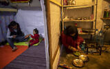 Illustrative: Syrian refugee Ayesha al-Abed, 21, right, prepares food as her Husband Raed Mattar, 24, left, plays with their daughter Rayan, 18 months old, before they break their fast on the first day of fasting month of Ramadan, at an informal refugee camp, in the town of Bhannine in the northern city of Tripoli, Lebanon, Tuesday, April 13, 2021. (AP Photo/Hassan Ammar)