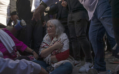 Women of the Wall activist Lesley Sachs clutches a Torah scroll while sitting on the floor amid protest at the Western Wall in Jerusalem on Nov. 5, 2021. (AP Photo/Maya Alleruzzo)
