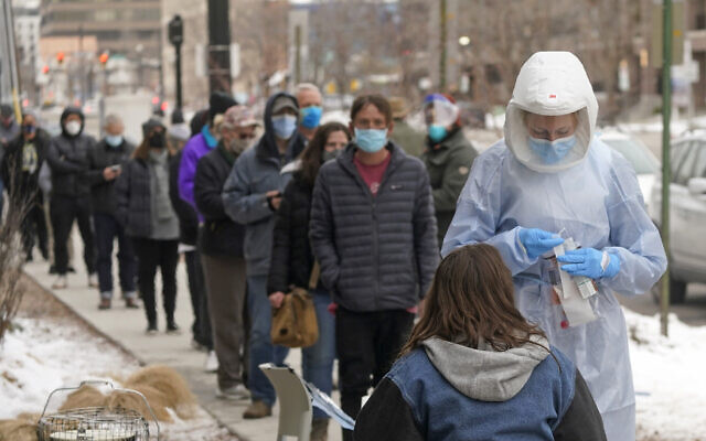 A member of the Salt Lake County Health Department COVID-19 testing staff performs a test outside the Salt Lake County Health Department, on Tuesday, January 4, 2022, in Salt Lake City. (AP/Rick Bowmer)