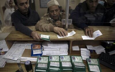 Palestinians wait to receive their national IDs at the civil affairs office in Gaza City, January 5, 2022. (AP Photo/ Khalil Hamra)