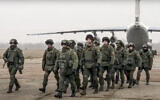 In this handout photo released by Russian Defense Ministry Press Service, Belarusian peacekeepers leave a Russian military plane at an airfield in Kazakhstan, January 8, 2022. (Russian Defense Ministry Press Service via AP)