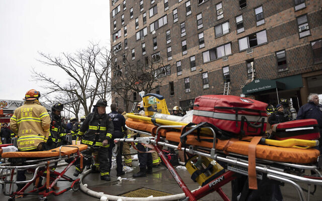 Firefighters work outside an apartment building after a fire in the Bronx, January 9, 2022, in New York. (AP Photo/Yuki Iwamura)