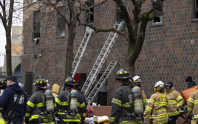 Ladders are seen erected beside the apartment building where a fire occurred in the Bronx on January 9, 2022, in New York. (AP Photo/Yuki Iwamura)