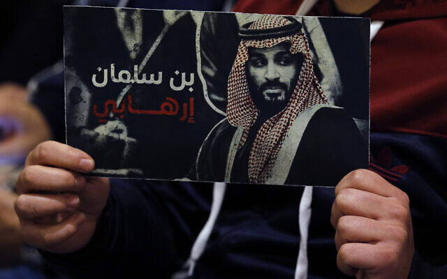 A supporter of the Iranian-backed Hezbollah terror group holds a poster of Saudi Prince Mohammed bin Salman with Arabic words that read: 'Bin Salman is a terrorist,' during a conference for Saudi opposition in the southern Beirut suburb of Dahiyeh, Lebanon, on January 12, 2022. (AP Photo/Bilal Hussein)