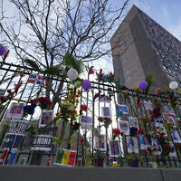 A memorial for the victims of an apartment building fire is displayed in front of the building in the Bronx borough of New York, January 13, 2022. (AP Photo/Seth Wenig)