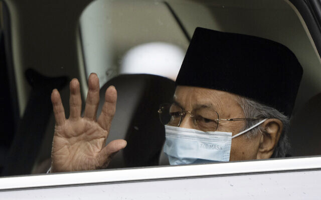 Malaysia's former prime minister Mahathir Mohamad, wearing a face mask, waves as he leaves the National Palace after meeting with the king in Kuala Lumpur, Malaysia, June 10, 2021. (AP Photo/Vincent Thian, File)