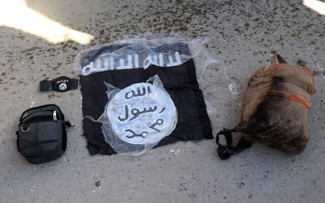 Illustrative: This photo provided by the Kurdish-led Syrian Democratic Forces shows the flag of the Islamic State and and bags taken from fighters who were arrested by the Kurdish-led Syrian Democratic Forces after IS militants attacked Gweiran Prison, in Hassakeh, northeast Syria, January 21, 2022 (Kurdish-led Syrian Democratic Forces, via AP, File)
