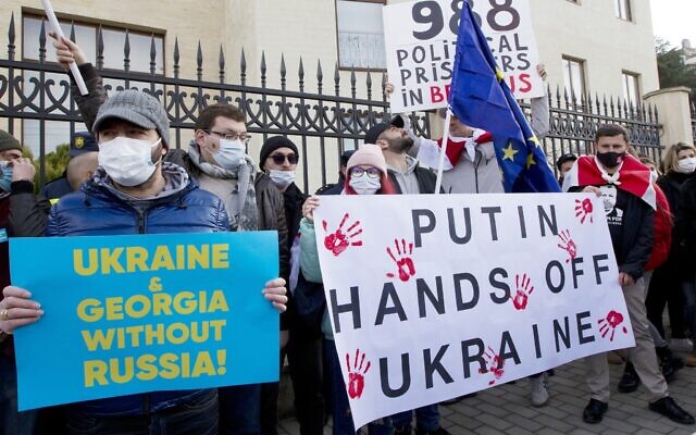 Georgian activists hold posters as they gather in support of Ukraine in front of the Ukrainian Embassy in Tbilisi, Georgia on Jan. 23, 2022. (AP Photo/Shakh Aivazov)