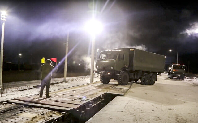 In this photo taken from video provided by the Russian Defense Ministry Press Service, a Russian military vehicle driving on a railway platform attends joint military drills in Belarus, in Russia, Monday, Jan. 24, 2022. (Russian Defense Ministry Press Service via AP)