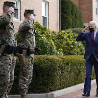 US President Joe Biden returns a salute as he walks by the Marine Barracks Washington after visiting the Honey Made store, Tuesday, Jan. 25, 2022, in Washington. (AP Photo/Andrew Harnik)