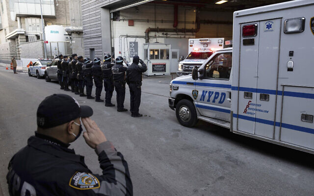 New York Police Department officers salute during the transfer of the remains of officer Wilbert Mora outside the NYU Langone hospital in New York, Tuesday, Jan. 25, 2022. (AP/Yuki Iwamura)