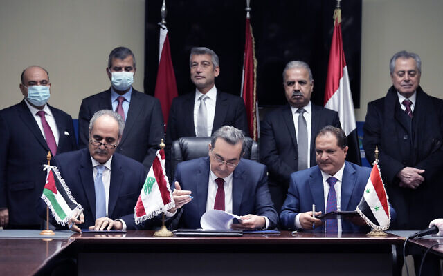 Front row from left to right, Amjad Rawashdeh, the Managing General Director of the Jordanian National Electric Power Company, Kamal Hayek, the Director of Electricity of Lebanon, and Fawaz al-Zaher, General Manager of Syrian Electricity Transmission and Distribution, sign deals to bring electricity from Jordan through Syria to Lebanon, at the Ministry of Energy and Water in Beirut, Lebanon, Jan. 26, 2022. (AP Photo/Bilal Hussein)