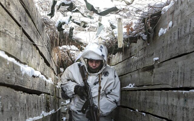 An armed serviceman walks along a trench on the territory controlled by pro-Russian militants on the frontline with Ukrainian government forces near Spartak village in Yasynuvata district of Donetsk region, eastern Ukraine, January 27, 2022  (AP Photo/ Alexei Alexandrov)