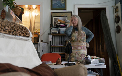 Nancy Rose, who contracted COVID-19 in 2021 and continues to exhibit long-haul symptoms including brain fog and memory difficulties, pauses while organizing her desk space, in Port Jefferson, New York, Jan. 25, 2022. (John Minchillo/AP)
