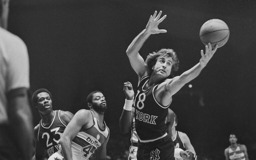 Ernie Grunfeld of the New York Knicks tries to grab on to a loose ball that was knocked from the hands of Greg Ballard of the Washington Bullets, left, during action in the first quarter of their exhibition game at the Capital Center in Landover, Maryland, October 22, 1982. (AP Photo/Joe Giza)