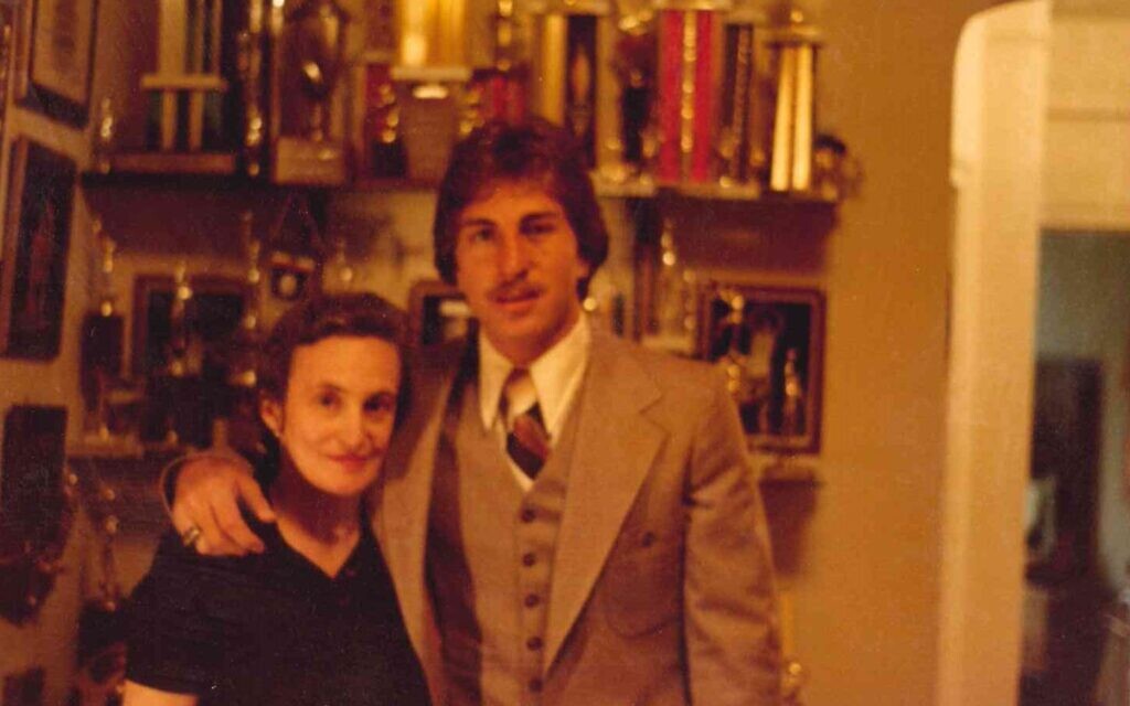 Ernie Grunfeld with his mother Lily Grunfeld in front of his trophy case in this undated photo. (Courtesy)