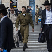 Illustrative: Ultra-Orthodox Jewish men walk along side Israeli soldiers in Jerusalem on December 5, 2019. (Olivier Fitoussi/ Flash90)