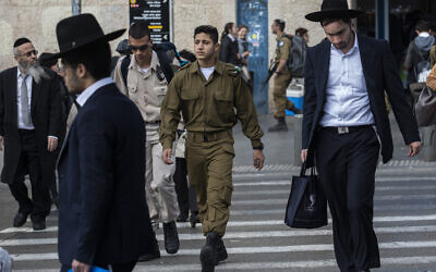 Illustrative: Ultra-Orthodox Jewish men walk along side Israeli soldiers in Jerusalem on December 5, 2019. (Olivier Fitoussi/ Flash90)