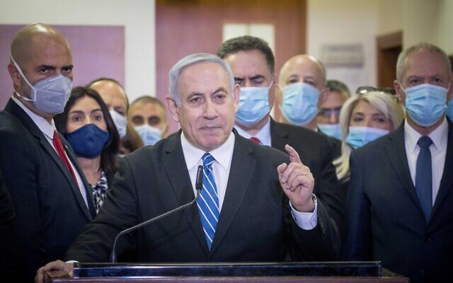 Prime Minister Benjamin Netanyahu delivers a statement before entering a courtroom at the Jerusalem District Court on May 24, 2020, for the start of his corruption trial. Alongside him from left are Likud MKs and ministers including Amir Ohana, Miri Regev, Nir Barkat, Israel Katz, Tzachi Hanegbi and Yoav Gallant. (Yonathan Sindel/Flash90)