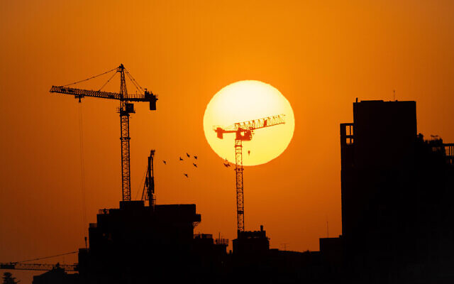 Cranes working at sunset on a construction site in Jerusalem, September 1, 2021. (Nati Shohat/Flash90)