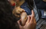 Illustrative -- Child receives a dose of the COVID-19 vaccine in Jerusalem on December 21, 2021 (Olivier Fitoussi/Flash90)