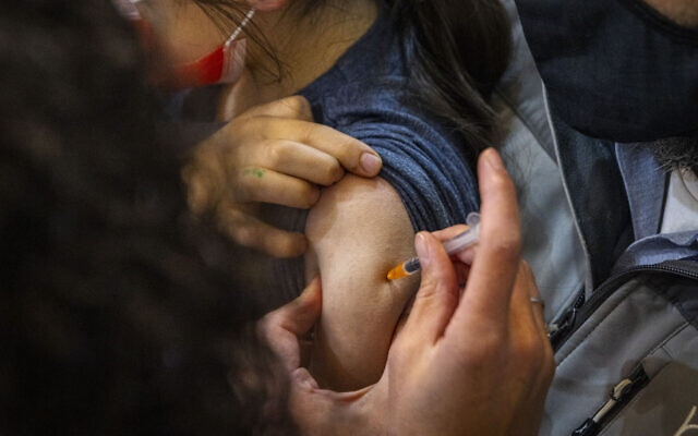 Illustrative -- Child receives a dose of the COVID-19 vaccine in Jerusalem on December 21, 2021 (Olivier Fitoussi/Flash90)