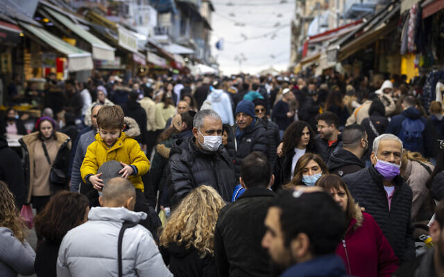 People shop at the Mahane Yehuda Market in Jerusalem on December 24, 2021. (Olivier Fitoussi/Flash90)