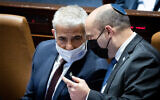 Prime Minister Naftali Bennett (R) and Foreign Minister Yair Lapid in the Knesset plenum, January 5, 2022. (Yonatan Sindel/Flash90)