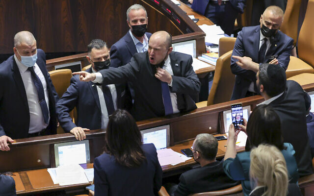 Prime Minister Naftali Bennett confronts and argues with opposition lawmakers in the Knesset during a vote on the electricity bill, Jerusalem, January 5, 2022 (Yonatan Sindel/Flash90)
