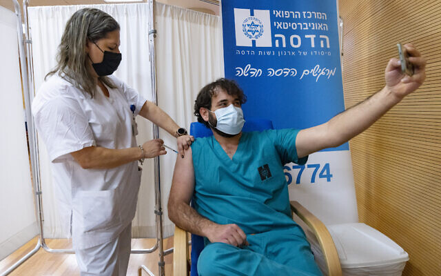 Medical workers and family members at Hadassah Hospital in Jerusalem receive their fourth doses of the COVID-19 vaccine on January 6, 2022. (Olivier Fitoussi/Flash90)