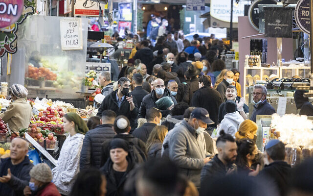 People, some wearing face masks, shop at the Mahane Yehuda market in Jerusalem, on January 13, 2022. (Olivier Fitoussi/Flash90)