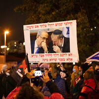 Demonstrators protest against a planned plea deal with Benjamin Netanyahu near the home of Attorney General Mandelblit, in Petah Tikva on January 15, 2022. (Chen Leopold/Flash90)