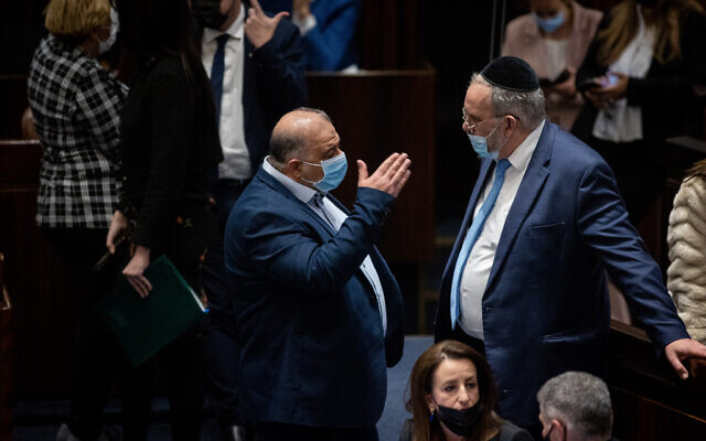 Ra'am party leader Mansour Abbas, left, and United Torah Judaism MK Yaakov Asher during a vote on the ultra-Orthodox draft bill at the Knesset in Jerusalem, on January 31, 2022. (Flash90)