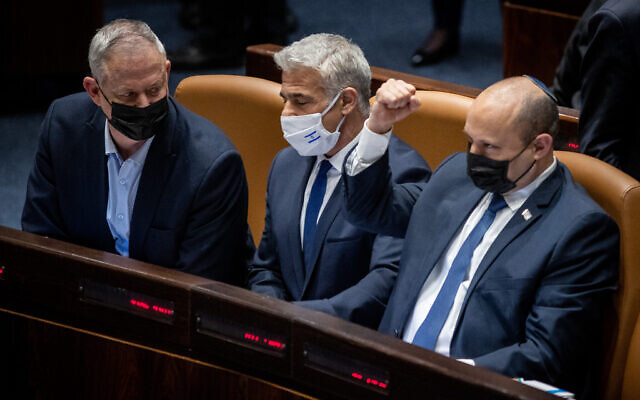 Prime Minister Naftali Bennett, right, Foreign Minister Yair Lapid, center, and Defense Minister Benny Gantz during a vote on the ultra-Orthodox draft bill at the Knesset in Jerusalem, January 31, 2022. (Flash90)