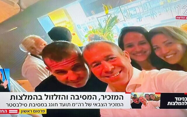 Government Military Secretary Avi Gil (right) poses for a selfie with NSO spokesman Oded Hershkovitz at a New Year's party in Tel Aviv. (Channel 12 screenshot)