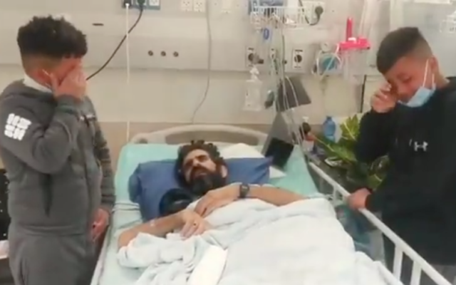 Palestinian administrative detainee Hisham Abu Hawash with his two sons at the Asaf Harofeh Medical Center on December 26, 2021. (Screen capture/ YouTube)