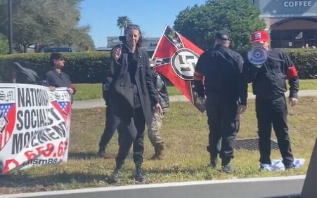 Neo-Nazi demonstrators with swastikas and 'National Socialist Movement' banners, stomping on an Israeli flag, in Orlando, Florida on January 29, 2022. (screen capture: Twitter/Luke Denton)