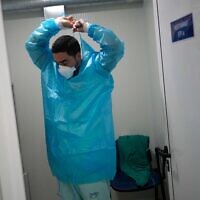 A medical worker prepares to enter the respiratory diseases unit of the Santa Maria Hospital in Lisbon, Portugal, January 21, 2022. (AP Photo/Armando Franca)