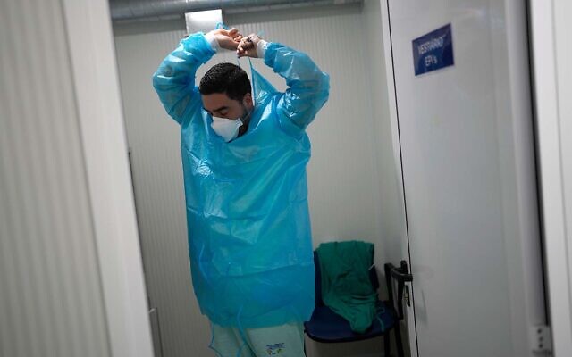 A medical worker prepares to enter the respiratory diseases unit of the Santa Maria Hospital in Lisbon, Portugal, January 21, 2022. (AP Photo/Armando Franca)