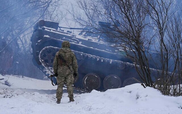 An Ukrainian serviceman and an armored personnel carrier near a front line position in the Luhansk area, eastern Ukraine, January 28, 2022. (AP Photo/Vadim Ghirda)